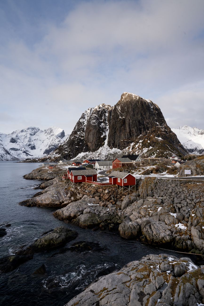 Arctic waters in Lofoten archipelago with red wooden cabins
